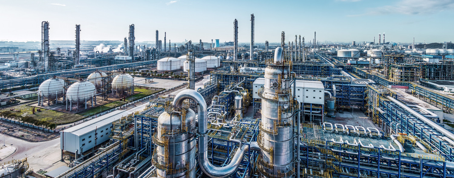 KI generiert: Das Bild zeigt eine große industrielle Anlage mit zahlreichen Rohrleitungen, Tanks und Schornsteinen, die auf eine Raffinerie oder chemische Fabrik hindeuten. Der Fokus liegt auf der komplexen Infrastruktur und den vielseitigen industriellen Strukturen.